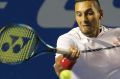 Nick Kyrgios plays a return to Serbia's Novak Djokovic.