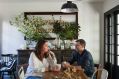 The couple sit at the dining table in front of a 300 year-old kitchen chest. “It’s the patina, honesty and integrity ...