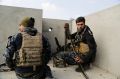 Iraqi federal police forces man a position on a roof of a house in on the edge of Mosul's Mamun neighborhood.