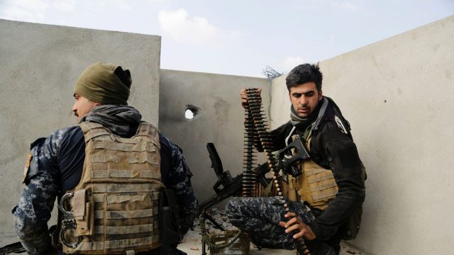 Iraqi federal police forces man a position on a roof of a house in on the edge of Mosul's Mamun neighborhood.