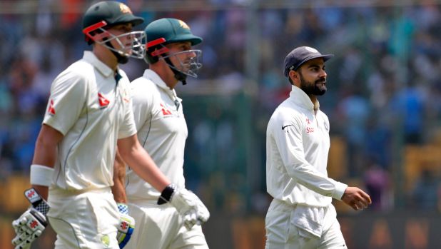 Last laugh: Virat Kohli walks off for the lunch break with Matt Renshaw and Shaun Marsh, having enjoyed Steve Smith's ...