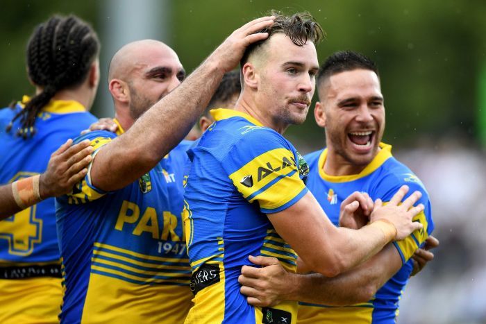 Clinton Gutherson of the Eels, (centre), celebrates with team mates after scoring a try