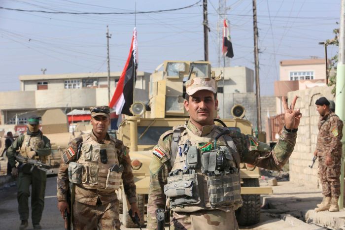 Iraqi soldier gestures "peace"