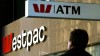 A pedestrian passes below a Westpac Bank sign