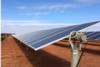 Long bank of chest high solar panels against blue sky on the red earth of the Sandfire copper mine near Meekatharra, WA