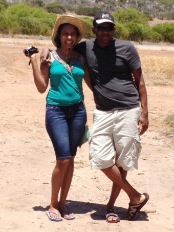 Chamari Liyanage stands on the side of the road holding a camera next to her husband and fellow doctor, Dinendra Athukorala.