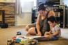 Jess McGurk at home with her two-year-old son Tom sitting on the lounge room floor reading. 