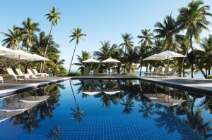 Sun loungers and parasols by the pool at Vomo Island Resort.