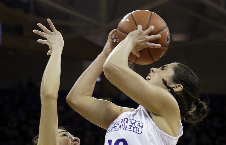 Washington’s Kelsey Plum, right, shoots over Utah’s Malia Nawahine as Megan Jacobs looks on in the first half of an NCAA college basketball game Saturday, Feb. 25, 2017, in Seattle. (AP Photo/Elaine Thompson)