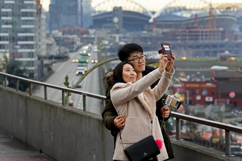 Joe Oh and his wife, Jiyoung Seo, both 26, from Arlington, Va., visit Seattle on their honeymoon. They said they’d never heard of the Viaduct but had taken this route looking for Pike Place Market. (Ken Lambert/The Seattle Times)