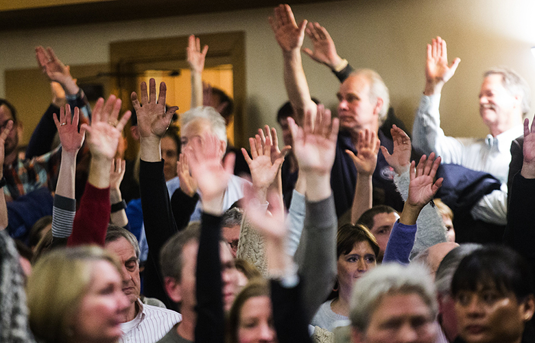 People raise their hands as they’re asked if they’ve been a victim of neighborhood crime in the last three years during a community forum to discuss concerns regarding public safety and crime rates in the Magnolia, Queen Anne and Ballard neighborhoods, held at Magnolia United Church of Christ on Wednesday, Jan.