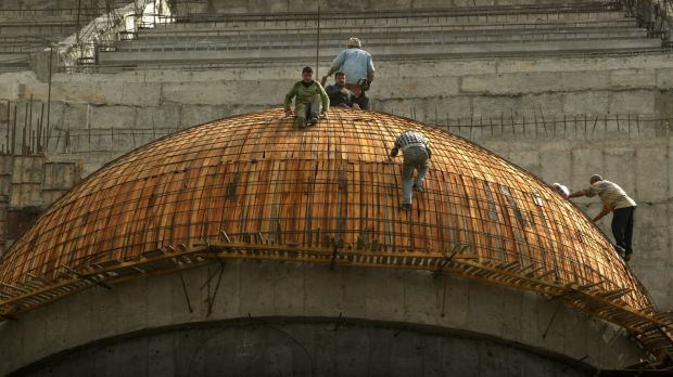 Two workers high above the Arahman Mosque being constructed in Baghdad in 2003.