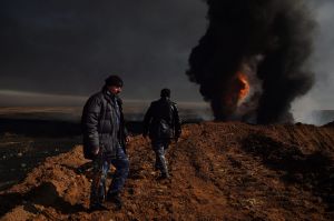 QAYYARAH OIL WELL FIRES Two men provide security at Well 77 in the Qayyarah oil fields. When ISIS retreated from the ...