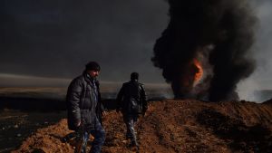 QAYYARAH OIL WELL FIRES Two men provide security at Well 77 in the Qayyarah oil fields. When ISIS retreated from the ...