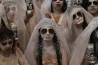 Women dressed to depict "La Llorana" or "The Weeping Woman" perform in a street theater act to remember the 43 missing ...