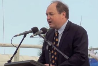 A shot of David Archibald at a podium speaking into a microphone.