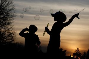 Children make soap bubbles at sunset in Chicago, Sunday, Feb. 19, 2017. 