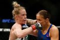 Brawl: Holly Holm, left, and Germaine de Randamie exchange blows.