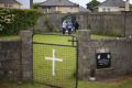 Members of the public gather in memory of the children buried here at the site of a mass grave for babies who died in ...