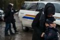 A woman comforts her son as his father is handcuffed by a Canadian police officer, having ignored the warning and ...