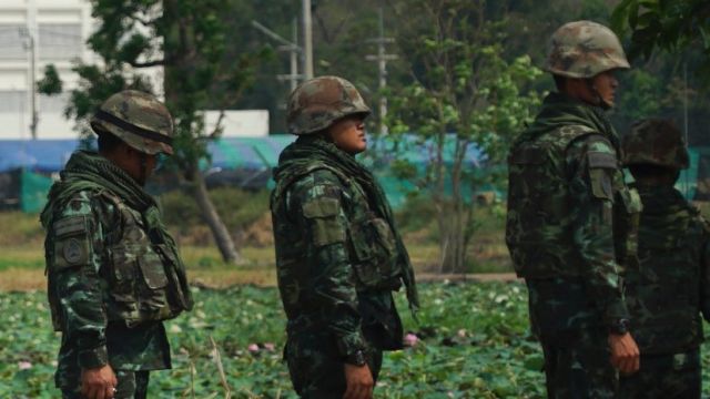 Troops stand in front of an unfinished medical centre at the Wat Dhammakaya temple compound in Pathum Thani province, ...