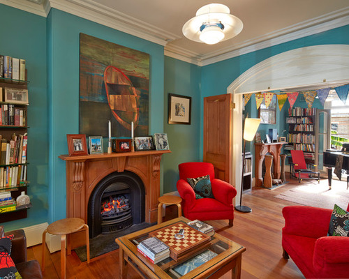 This is an example of an eclectic enclosed living room in Sydney with blue walls, medium hardwood floors, a standard fireplace and a tile fireplace surround.