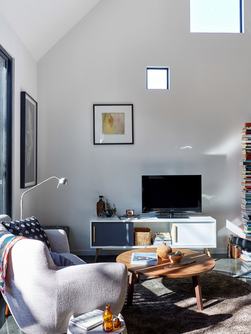 This is an example of a contemporary formal living room in Melbourne with white walls and a freestanding tv.