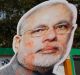 Bharatiya Janata Party supporters raise cutouts of Indian Prime Minister Narendra Modi as they celebrate winning seats ...