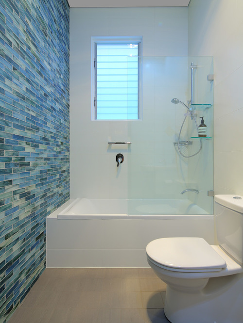 This is an example of a contemporary master bathroom in Sydney with glass tile, a drop-in tub, a shower/bathtub combo, white walls and blue tile.