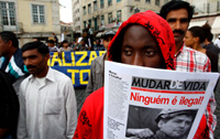 African-born migrant holds a poster reading “Nobody is illegal”, October 2008 © EPA