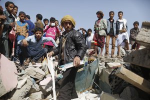 A man, center, inspects his shop destroyed by a Saudi-led airstrike at a market in Sanaa, Yemen, Monday, July 20, 2015.