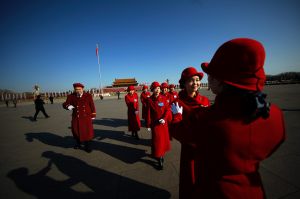 In this Sunday, March 5, 2017 photo, a hospitality staffer poses her colleagues for photographs on Tiananmen Square ...