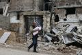 A man with a baby in a bombed-out area of Aleppo, Syria, in January.