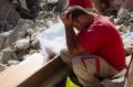 Rescuers pause in Amatrice, central Italy, where a 6.1 earthquake struck in August last year.
