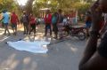 People stand by the body of a man who died when a bus crashed into a crowd watching street musicians in Haiti.