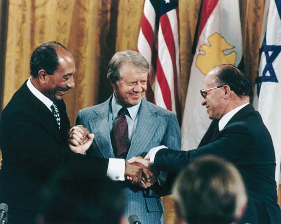 Egyptian President Anwar el-Sādāt (left), U.S. President Jimmy Carter, and Israeli Prime Minister Menachem Begin shaking hands at the White House after signing the Camp David Accords peace treaty between Israel and Egypt, September 17, 1978.