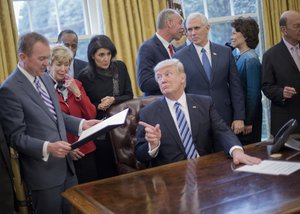 President Donald Trump looks over towards Budget Director Mick Mulvaney, left, after signing an executive order in the Oval Office of the White House in Washington, Monday, March 13, 2017.