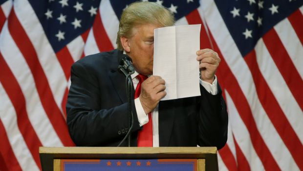 "There's nothing to learn from them," Donald Trump said of his tax returns. Here, he stares at a sheet of talking points ...