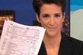 MSNBC host Rachel Maddow holds up documents purported to be Donald Trump's tax return.