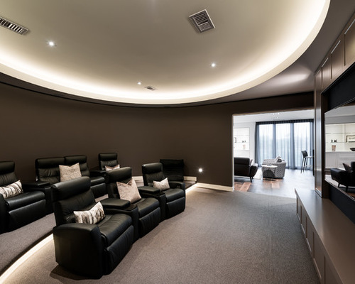 Photo of a contemporary enclosed home theatre in Melbourne with brown walls, carpet and a wall-mounted tv.