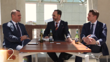 Liberal MPs Tim Wilson and Andrew Hastie sit at a table holding Coopers beers