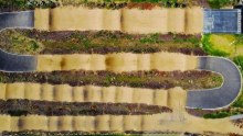 An aerial view of tennis courts and a bumpy BMX track