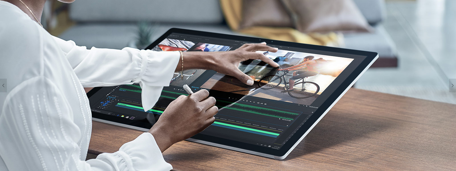 Woman using Surface Pen to draw on Surface Studio screen while pinch-zooming with her other hand