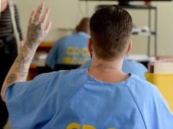 A student raises his hand during a class at the California Institution for Men in Chino, California