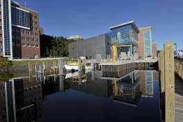 FILE - In this July 24, 2012, file photo, the Great Lakes Research Center is reflected in the waters of the docking area with RV Agassiz ready to go at Michigan Tech University in Houghton, Mich. The closure of a regional airport could force residents of Houghton in upper Michigan to drive eight hours to catch a flight. President Donald Trump’s budget proposes deep spending cuts to scores of domestic programs that, in some cases, risk backlash from the voters that helped propel him to the White House. (Dale G. Young/Detroit News via AP)