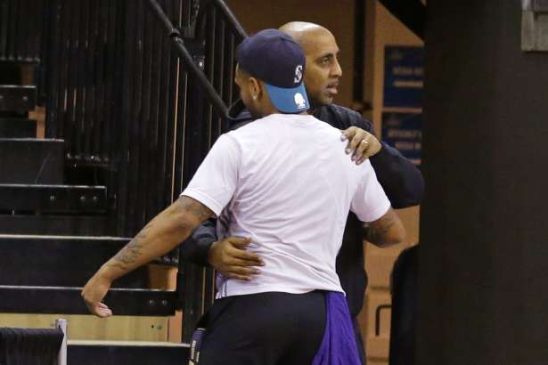 Former Washington men's basketball coach Lorenzo Romar, rear, hugs guard David Crisp, Wednesday, March 15, 2017, in Seattle. Washington fired Romar Wednesday, after 15 seasons.