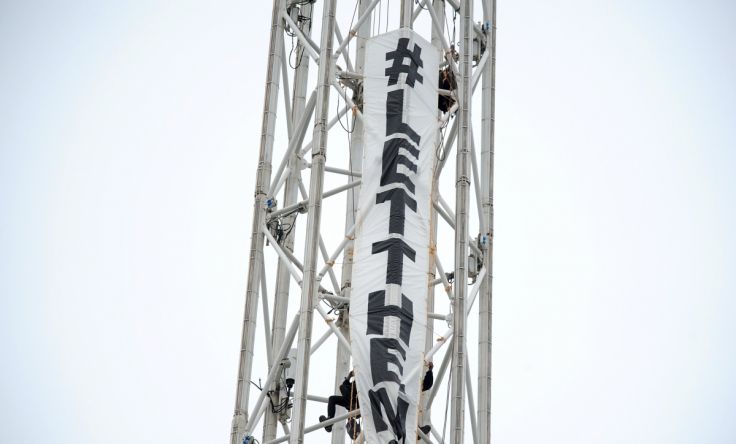 Protesters climb a spire