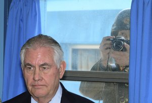 A North Korean soldier, right, tries to take a photograph through a window while U.S. Secretary of State Rex Tillerson visits at the U.N. Command Military Armistice Commission meeting room at the border village of Panmunjom, which has separated the two Koreas since the Korean War, South Korea, Friday, March 17, 2017.