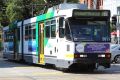 A tram travels down Victoria Parade.