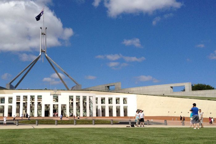 Tourists take photos outside Parliament House